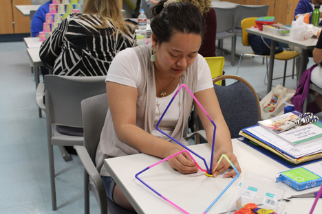 Student instructor uses colorful straws to build with.