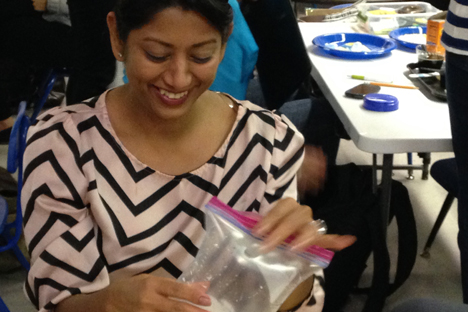 Student instructor uses a plastic baggie to experiment with a baking soda and vinegar mixture.